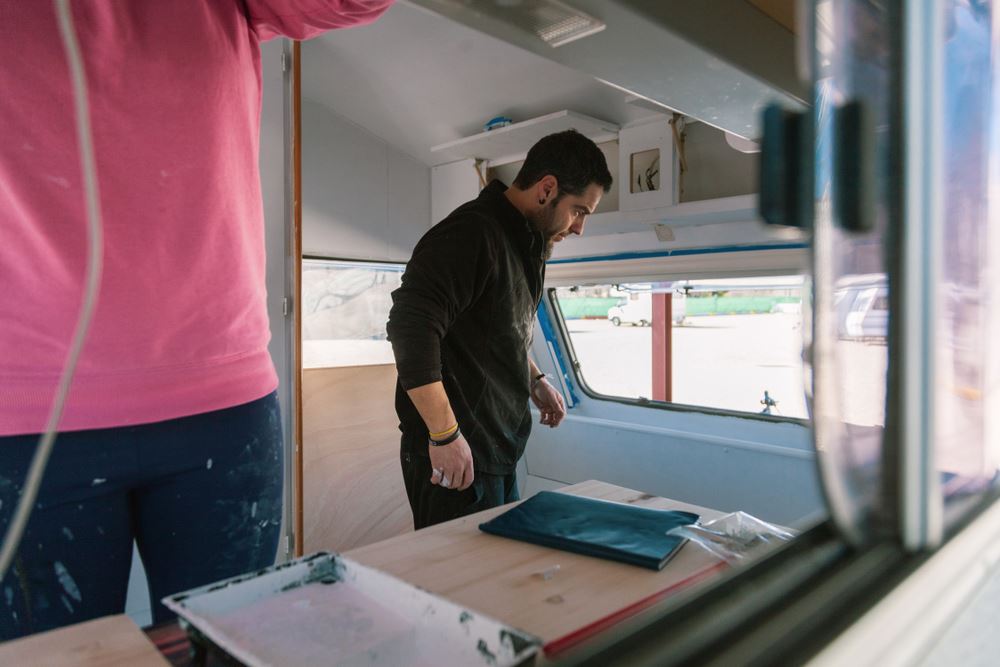  hombre de pie dentro de una caravana a medio construir